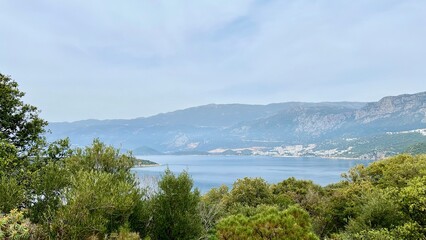Horizontal photo of a bay surrounded by mountains and green hills. Mediterranean landscape, summer vacation, tourism, nature, ecotourism, peaceful scenery, inspiring views, Mediterranean Sea, Turkey.