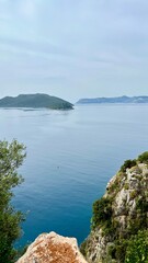 Vertical photo of a bay surrounded by mountains and green hills. Mediterranean landscape, summer vacation, tourism, nature, ecotourism, peaceful scenery, inspiring views, Mediterranean Sea, Turkey.