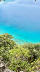 Vertical photo of the Mediterranean coastline with bright blue and turquoise water. Summer vacation, coastal landscape, travel in Turkey and Greece, seaside scenery, clear sea, beach destination. 