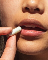 Close up shot of woman taking a supplement vitamin 