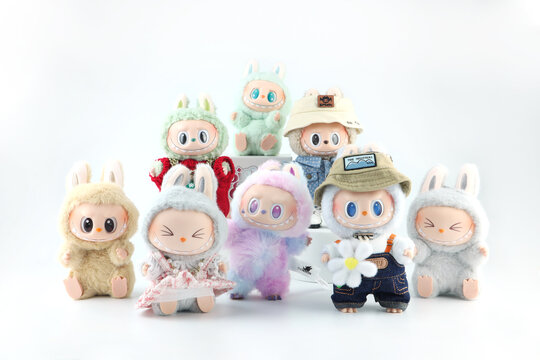 art toys Labubu key chain collection from Pop Mart blind box collectable cute toys display on white shelf background at Pop mart flagship store during new release big into energy labubu macaron doll