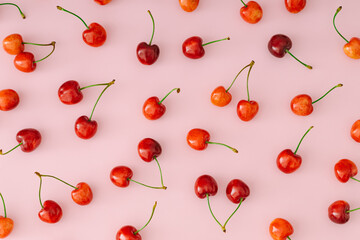Summer pattern composition made of fresh natural red cherries on pastel pink background. Minimal cherry fruit concept. Cherry aesthetic. Flat lay style. Top view.
