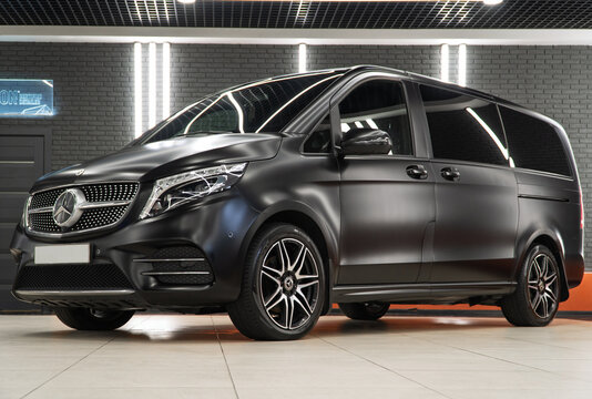 Black matte Mercedes-Benz V 300 d luxury MPV in the showroom after wrapping in matte satin and after detailing. Car wrapping, tuning, styling. Germany car. 