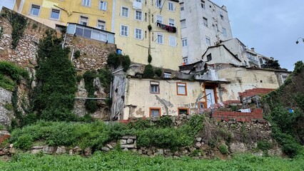 Steep, ivy-clad tenements in vibrant pastel hues cast a serene, forgotten charm, echoing ancient...