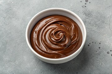 Chocolate Pudding in a White Bowl on a Grey Background