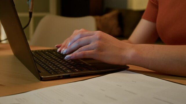 Closeup of clipboard with script and unrecognizable female hands with manicured typing on keyboard in background