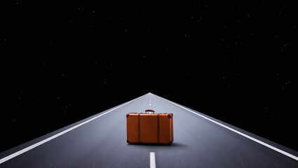 Orange suitcase on an endless road under a starry night sky, symbolizing travel, adventure, and the journey into the unknown.