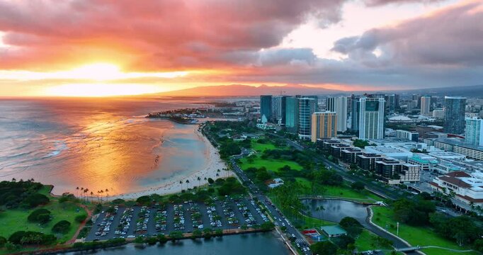 Spectacular colorful cloudy reflects in the vast waterscape of the Pacific Ocean. View on the beautiful green waterscape and cityscape of Honolulu, Hawaii, USA. Aerial perspective.