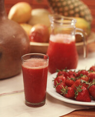 Strawberries fruit juice glass and jar.