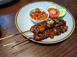 Delicious Chicken Satay Skewers with Peanut Sauce and Fresh Vegetables