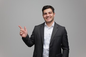 Confident young man in a suit gestures enthusiastically towards a bright opportunity with a smile
