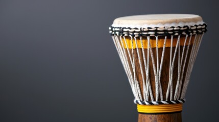 A close-up view of a drum with a white top and yellow band.