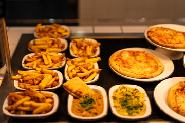 Variety of Delicious French Fries, Curries, and Pizzas in Serving Plates