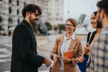 A group of business people engaging in a lively discussion outdoors in an urban city setting,...