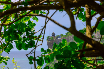 Uluwatu Temple in Bali the land of the Gods. Sitting on top of a forest cliff overlooking turquoise blue beach. beautiful colourful skies of Bali island Indonesia 