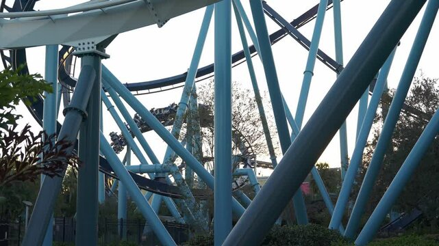 Experience the thrill of a roller coaster ride at amusement park as the sunset. Enjoy the excitement of steep drops and sharp turns while surrounded by vibrant scenery and fellow riders.