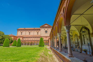  Ferrara, Italy - May 17, 2025: Wide angle view of San Cristoforo church in Charterhouse of Ferrara cloister with columns framing the main building. Summer day in Ferrara, Italy