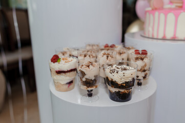 Elegant Dessert Table Featuring Chocolate Mousse Cups at a Sophisticated Event with Pink Decorations and Modern White Furniture
