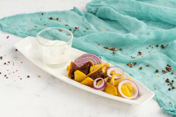 Gourmet platter with yellow beets, figs, onion rings, and yogurt dip on elegant white plate