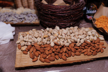 Assortment of nuts presented on wooden boards and in wicker baskets at a catering event with...