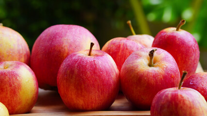 A handful of bright red apples lie on the ground.