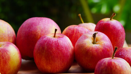 A handful of bright red apples lie on the ground.