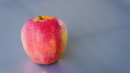 A handful of bright red apples lie on the ground.