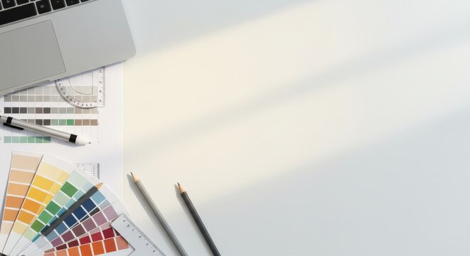 Creative design workspace with laptop and color swatches - Powered by Adobe