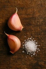 Garlic cloves and coarse sea salt on rustic wooden table. AI-generated.