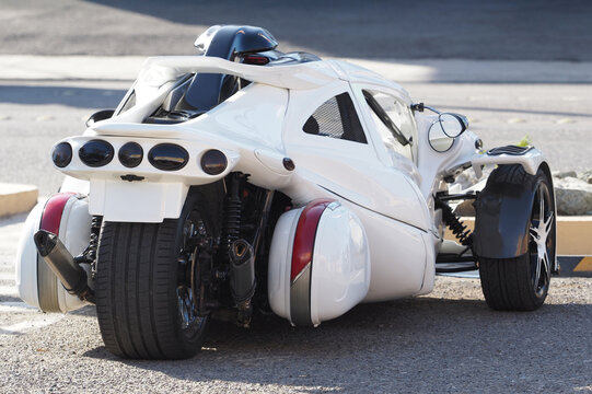 White trike three-wheeled vehicle autocycle parked on the street during daytime.