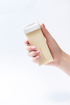 Hand holding roll on waxing cartridge for hair removal