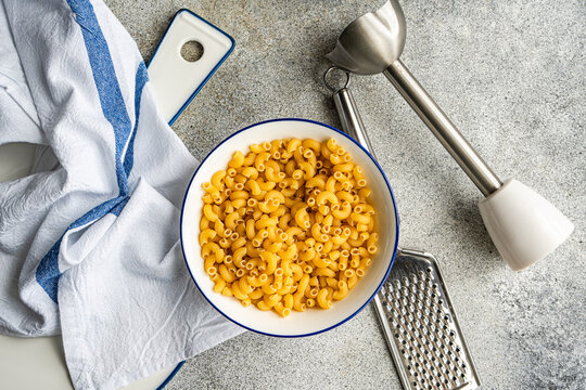 Chifferi rigati pasta in a bowl with kitchen utensils