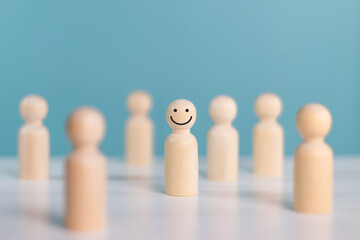 Individuality, unique, personality, management and leadership concept. Happy and enjoy wooden people symbol standing out from the crowd