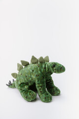 dinosaur stuffed animal sitting on a white background