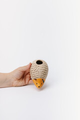 hand holding ceramic hedgehog planter on white background