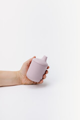hand holding purple silicone sippy cup
