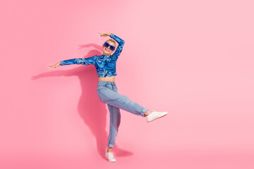 Cheerful young woman in trendy casual outfit expressing joy against a vibrant pink background