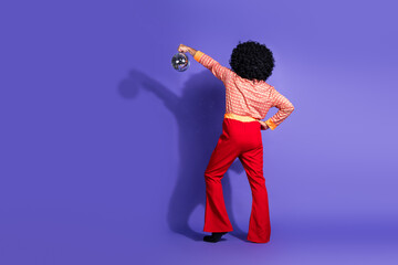 Retro styled individual posing confidently in vibrant outfit, embodying 1970s disco culture with a...