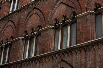 Obraz premium Old brick orange building wall with windows in the old europe city on the street. Italy town with vintage style