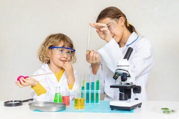 Laboratory examination of a child with test tubes, reagents and a microscope. Selective focus.