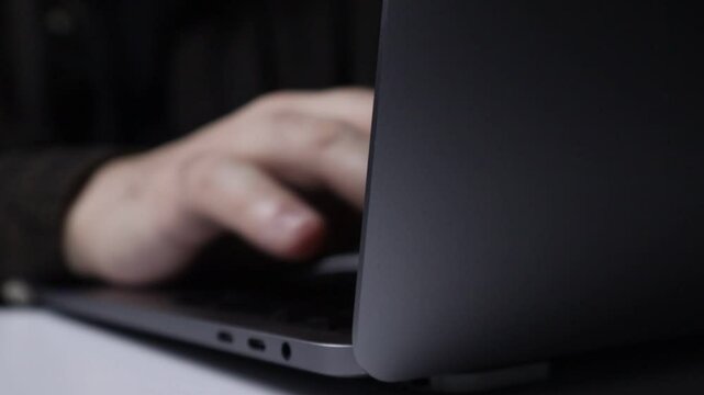 Men's fingers delete text message with backspace button on laptop