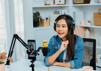 Host channel Asian influencer talking in broadcast wearing headsets on social media live on...