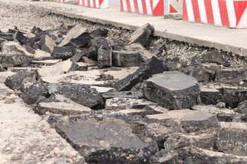 Asphalt broken into large pieces on the road. Repair work in the city. Road repair work. A mountain...