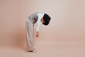 Businesswoman Posing in Beige Formalwear Against a Neutral Background Illustrating Office Fashion...