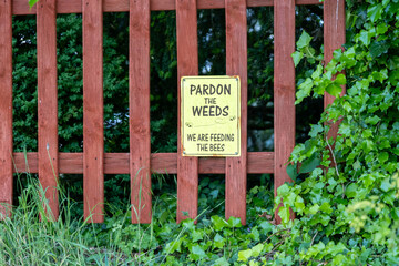 Bee conservation sign on a wooden fence in the countryside