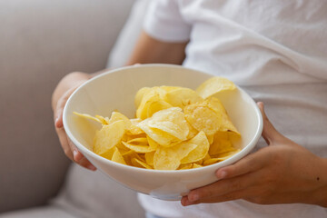 Close-Up of Hands Holding White Bowl of Crispy Potato Chips
