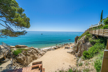Fototapeta premium Tourists relaxing at idyllic sandy beach on costa brava, catalonia