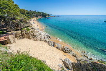 Tourists enjoying summer at scenic beach in costa brava, calonge, spain