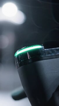 Close view of a parked electric scooter bike handle with soft bokeh light effects in the background and a blurred view of cars passing by