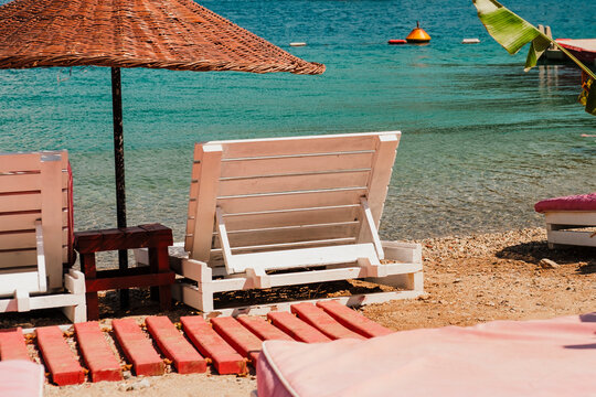 summer vibes on sunny hot windy day at beach club with pink umbrellas and sunbeds, amazing nature of Turkish riviera